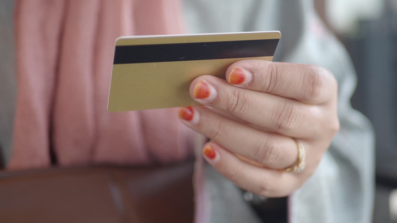 mujer con una tarjeta de crédito de oro