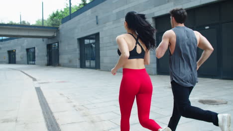 vista trasera de una pareja joven corriendo al aire libre juntos