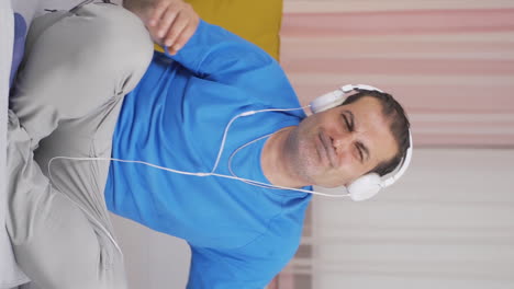 Vertical-video-of-Happy-man-listening-to-music-with-headphones.