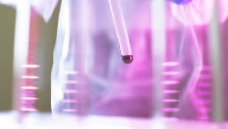 close up of glass tube used for blood test by scientist studying results for coronavirus outbreak on people