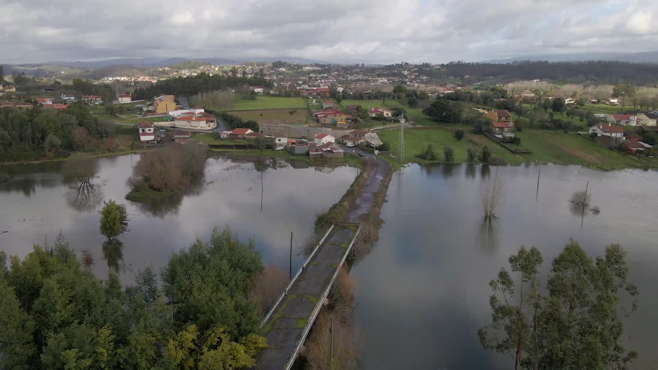 Una ripresa aerea dall'alto mostra un'estesa inondazione attraverso un terreno pianeggiante vicino a Lamas do Vouga, con l'acqua che copre campi, sentieri e canali di drenaggio. Drone che si sposta a destra