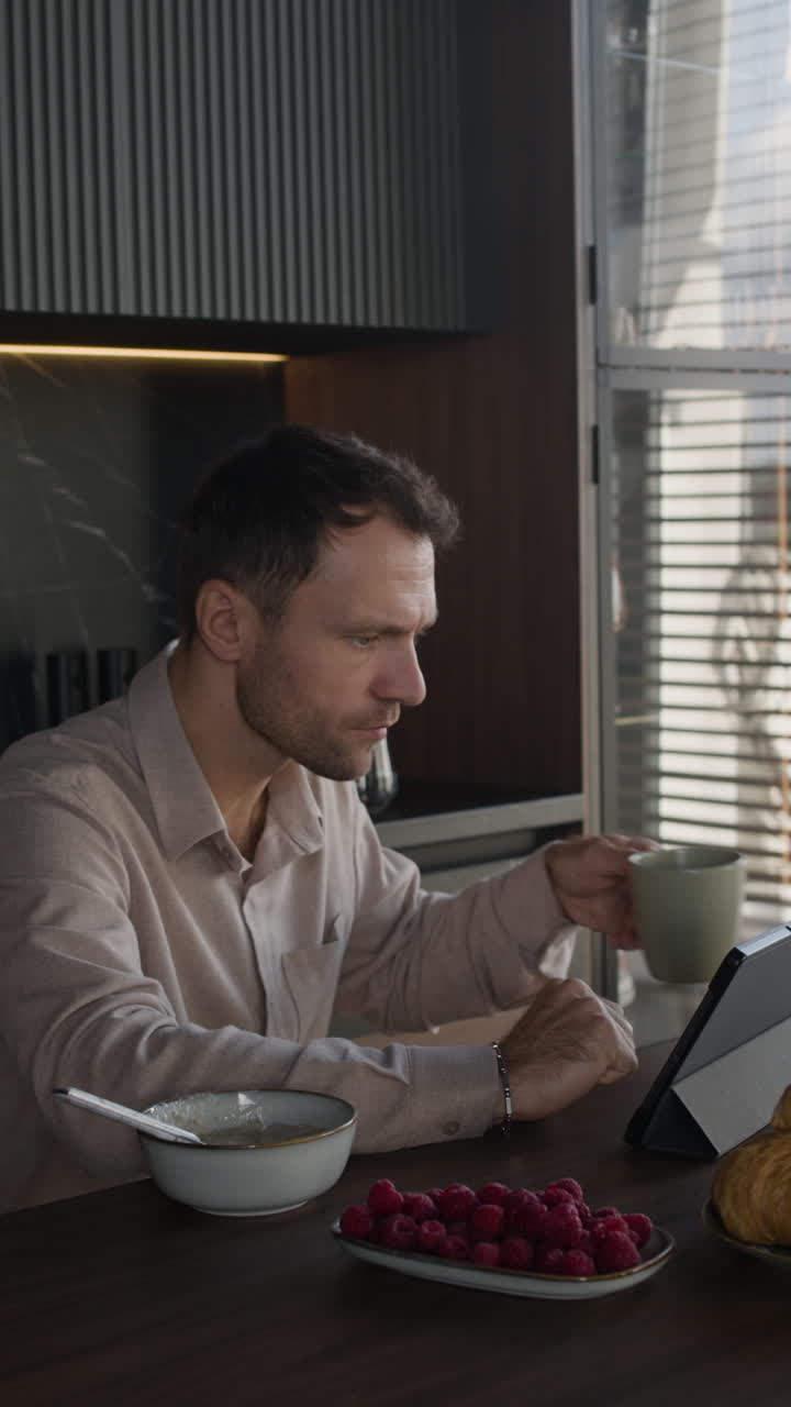Mann som spiser frokost på kjøkkenet