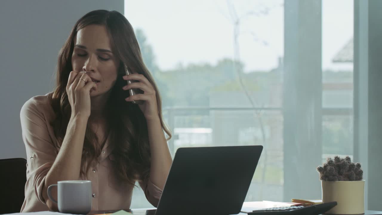 mujer de negocios comprobando la computadora portátil en casa. persona feliz hablando por teléfono móvil.