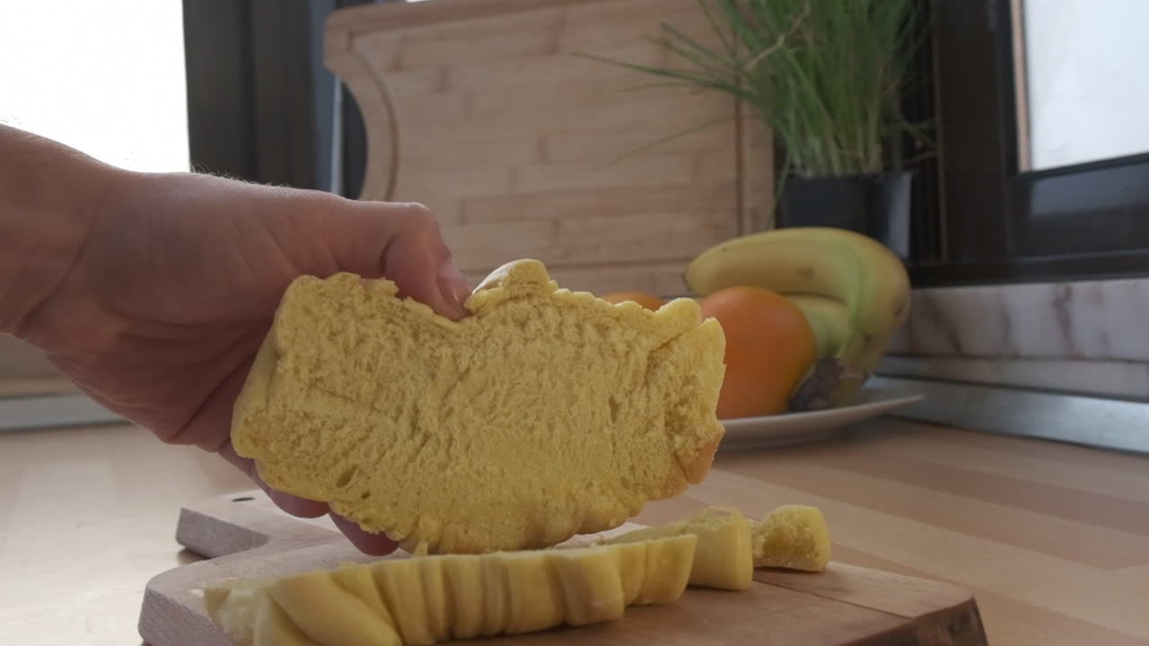 Croissant tagliato su un tagliere di legno in cucina - rallentatore estremo.