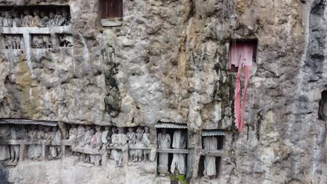 ancient torajan tau tau effigies in cliff graves, sulawesi