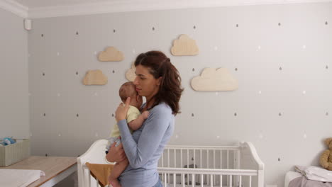 mother comforting baby son in nursery