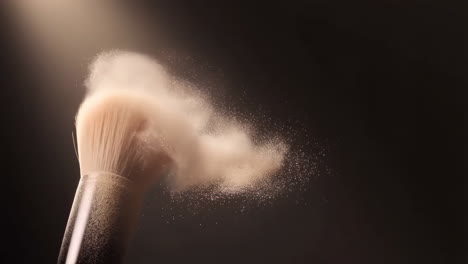 makeup brush dispensing powder in slow motion