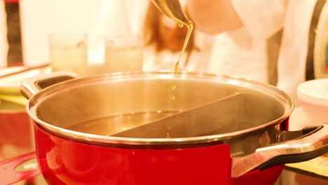 ladle pouring broth into a hot pot