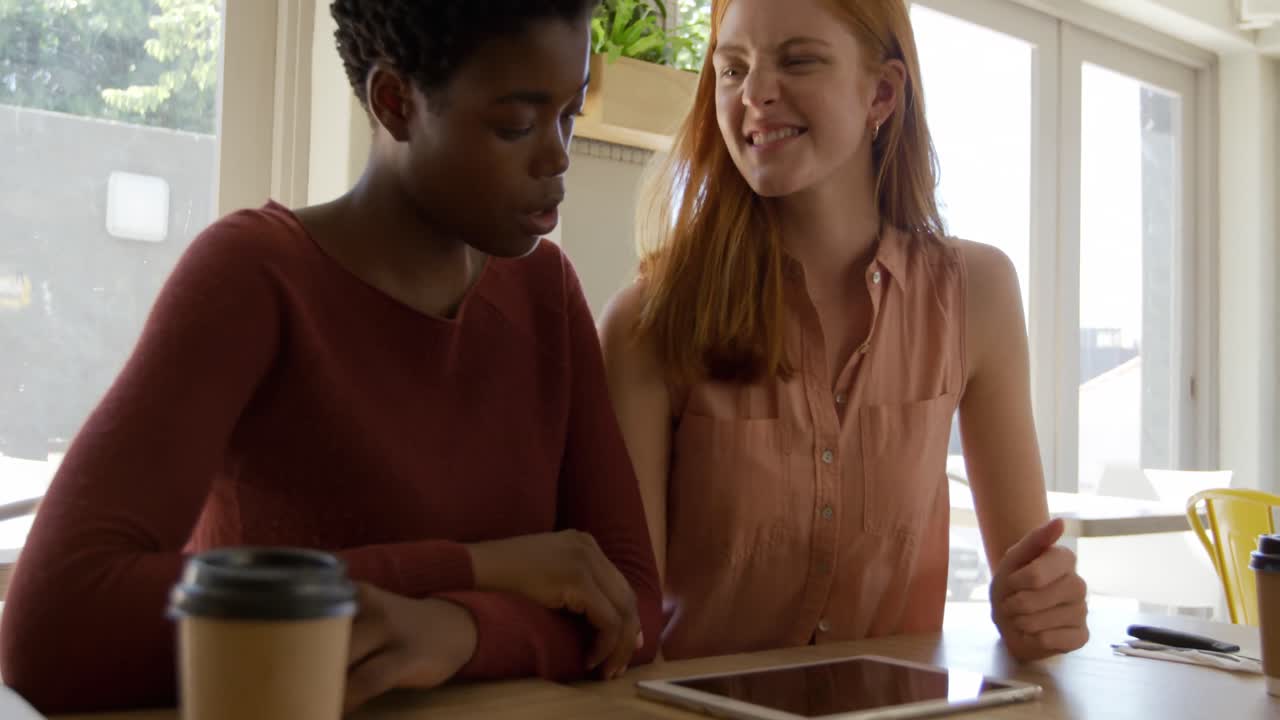 Young adult female friends hanging out in a cafe