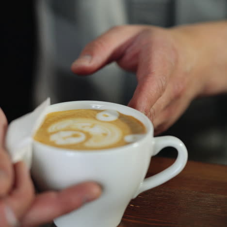 professional barista works in a coffee shop close-up, draws a pattern on a cappuccino cup sqare video