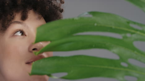 close up portrait beautiful mixed race woman with soft natural skin complexion hiding behind plants peeking playful attractive female enjoying healthy skincare beauty concept