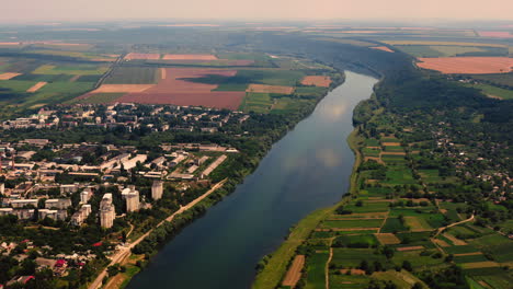 aerial drone landscape view of the dniester river, flowing through a town and countryside, moldova