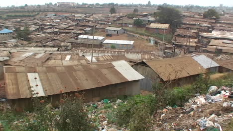 people standing on a hill look out over the surrounding shanty town area