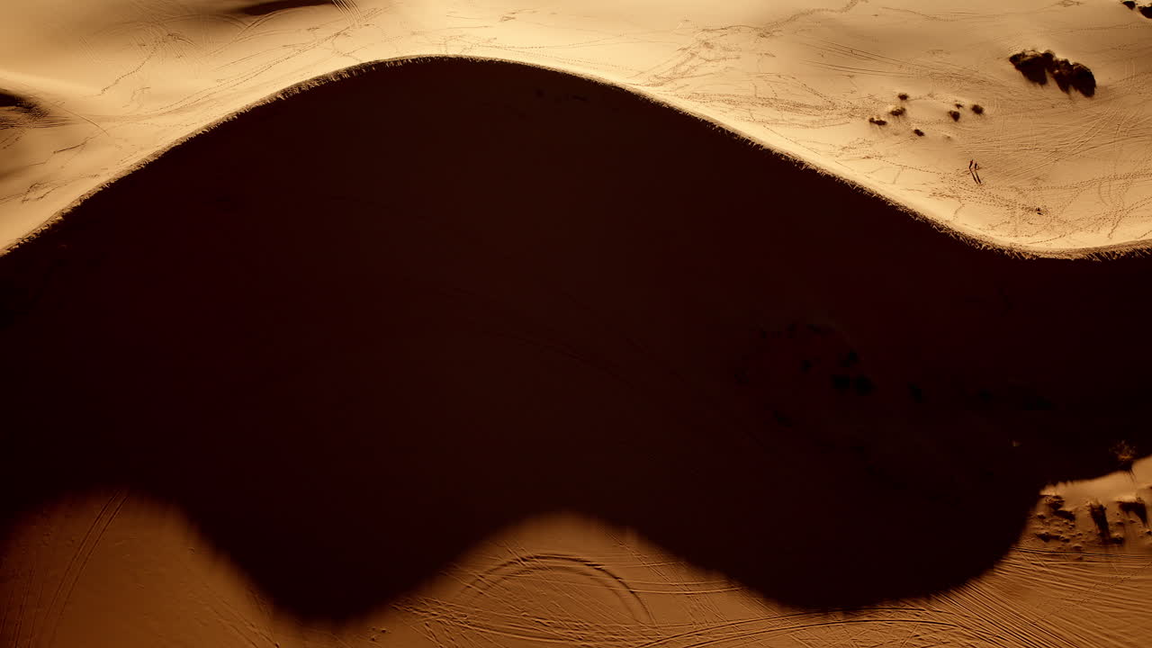 An aerial perspective offers a surreal glimpse into the wavy, colorful terrain of the pink dunes.
