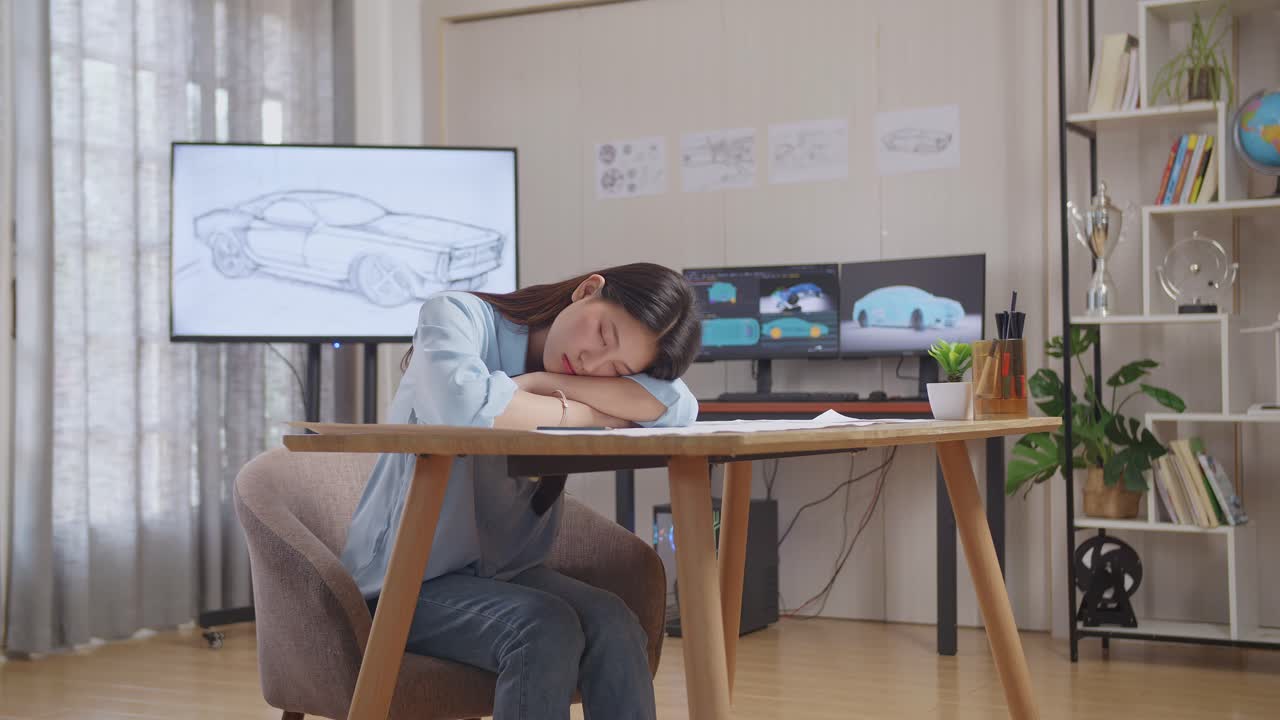 피곤한 자동차 디자이너가 책상에서 잠을 자고