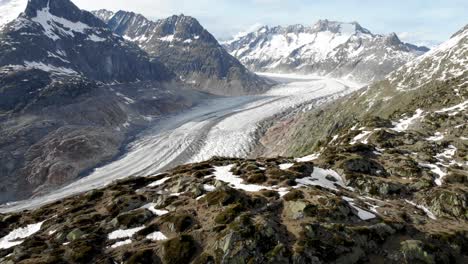 aerial flyover alongside a ridge overlooking the aletsch glacier in wallis, switzerland, which is the longest glacier of the swiss alps and europe