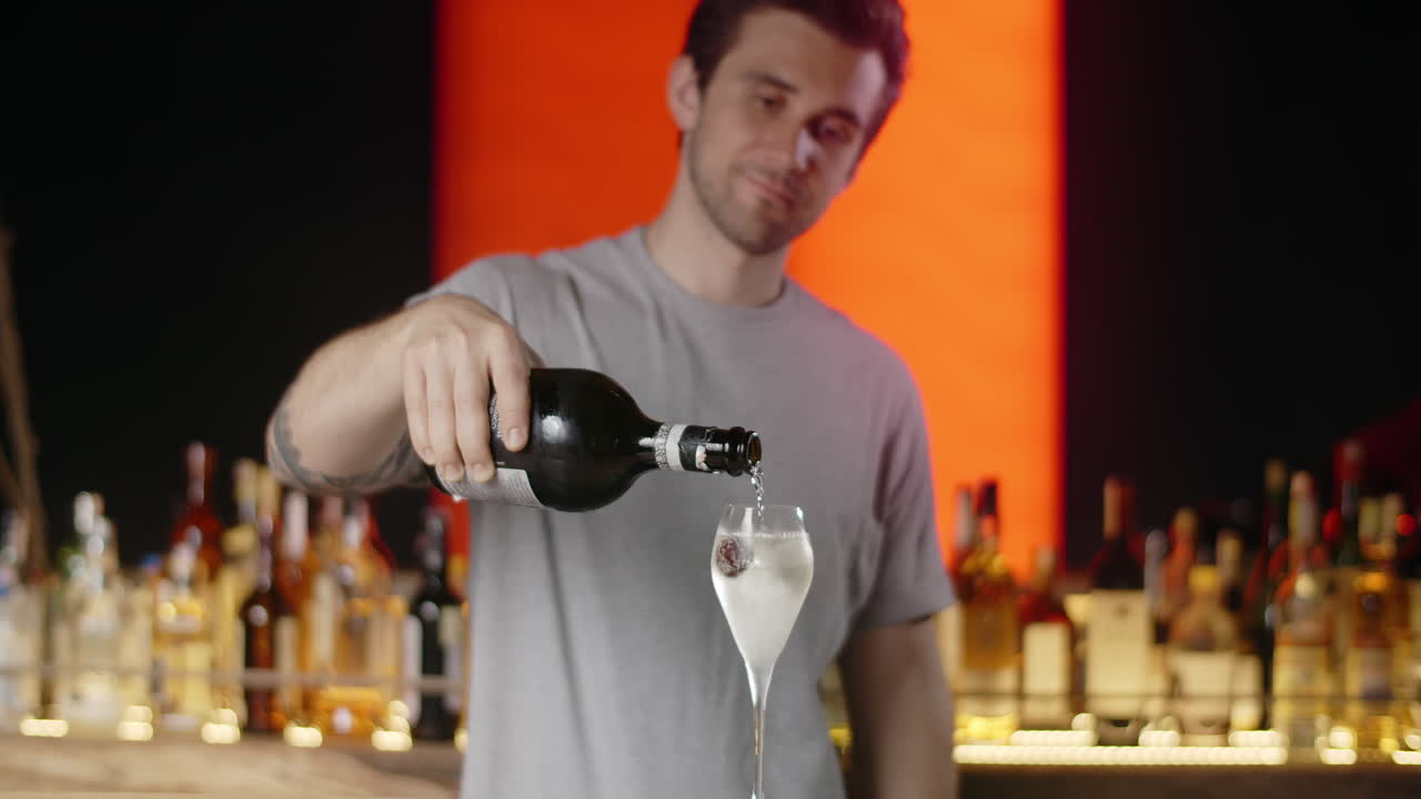 Bartender pouring champagne into a cocktail glass