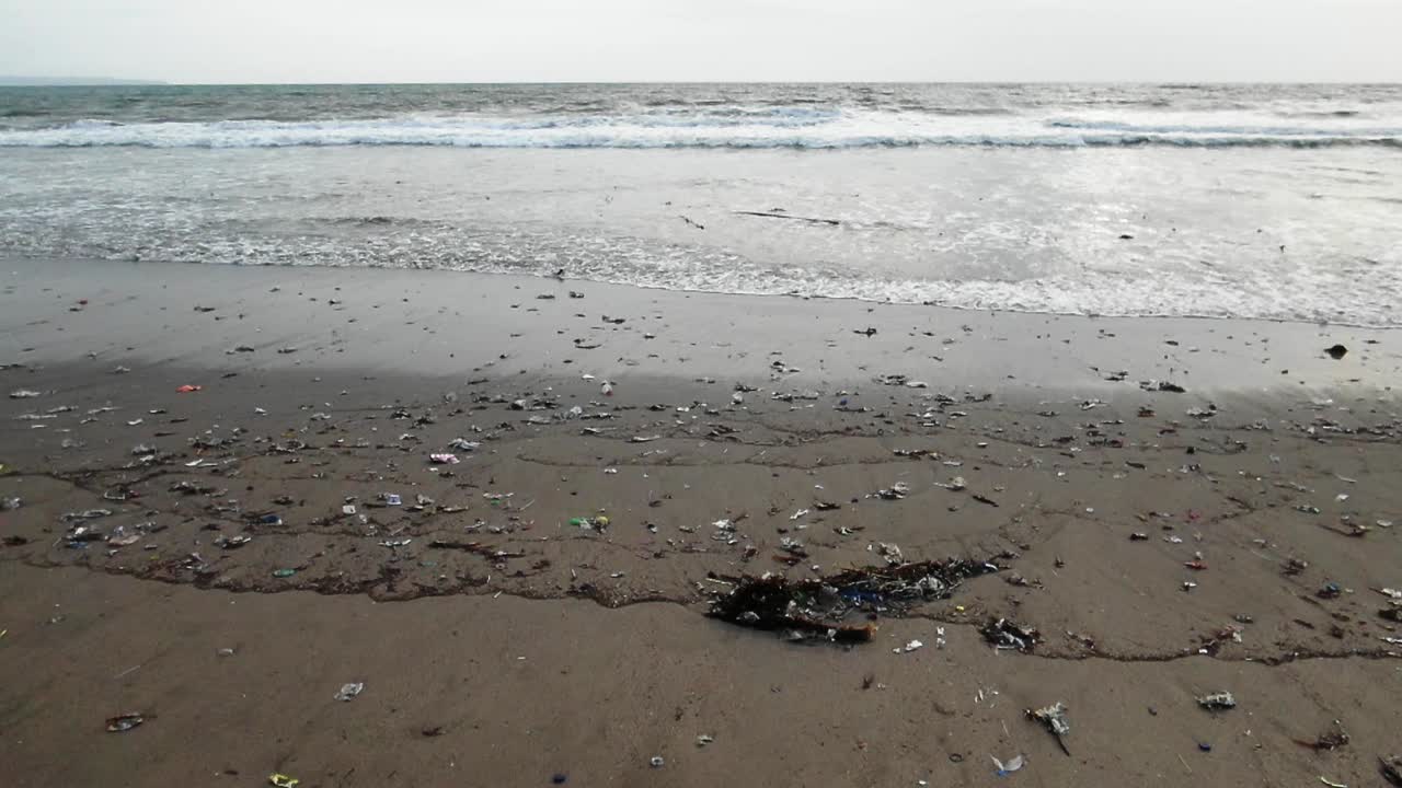 toma en cámara lenta mientras las olas golpean la playa, el océano contaminado