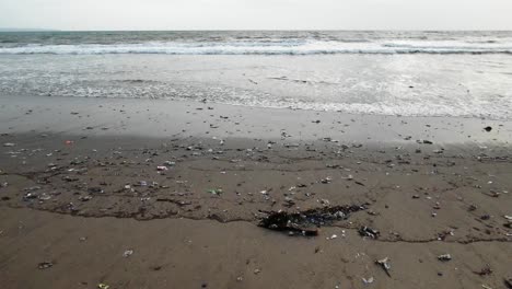 Toma-En-Cámara-Lenta-Mientras-Las-Olas-Golpean-La-Playa,-El-Océano-Contaminado