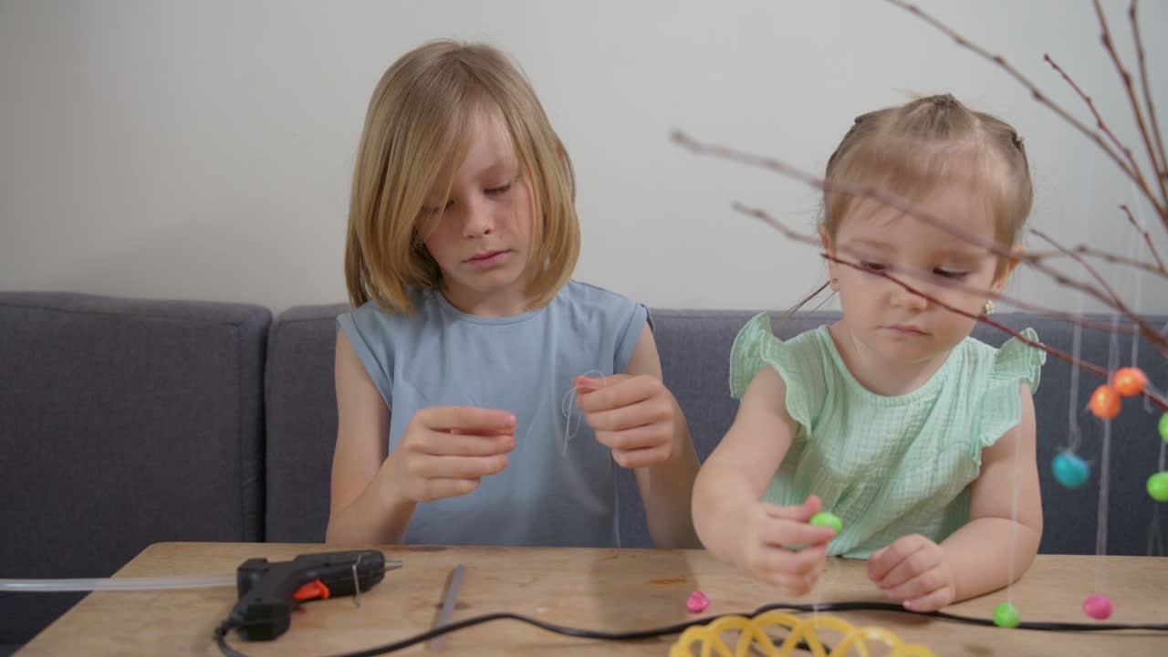 Due bambine che realizzano decorazioni pasquali a casa