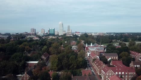 Aerial-Push-Old-Salem-Im-Vordergrund-Mit-Winston-Salem-NC-Skyline-Im-Hintergrund