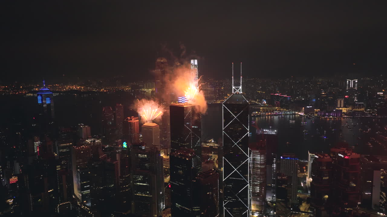 gran tiro aéreo de fuegos artificiales sobre el centro de cheung kong y la casa jardine, mirando al sur hacia kowloon, hong kong por la noche