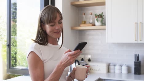 una mujer caucásica de mediana edad disfruta de un café matinal en casa.