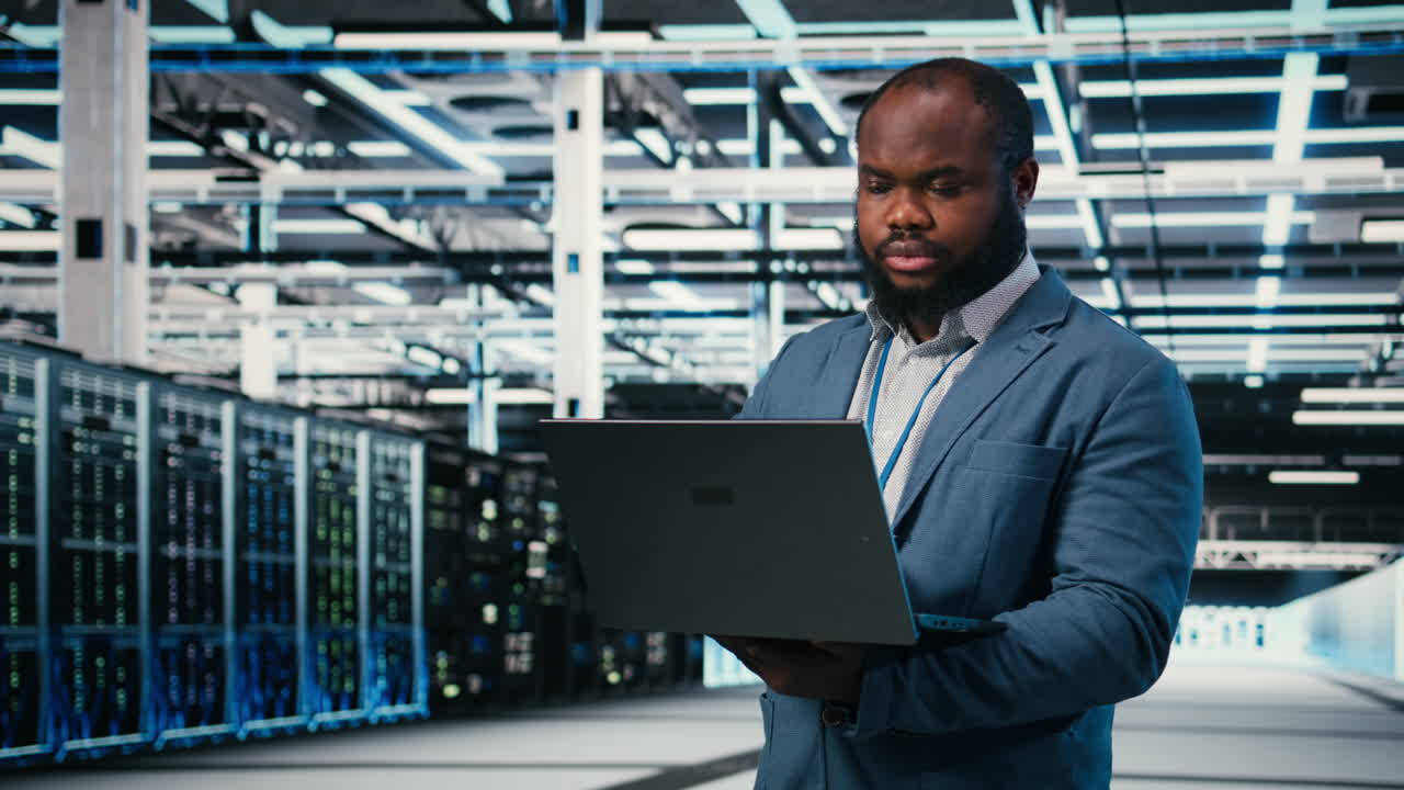 IT Engineer Using Laptop in Server Room