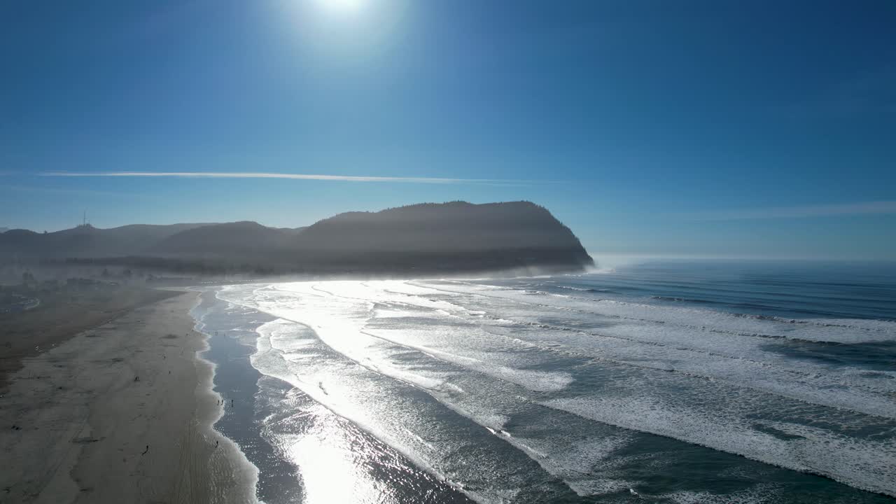 4K aerial drone shot floating over Seaside, Oregon beach on a sunny day.