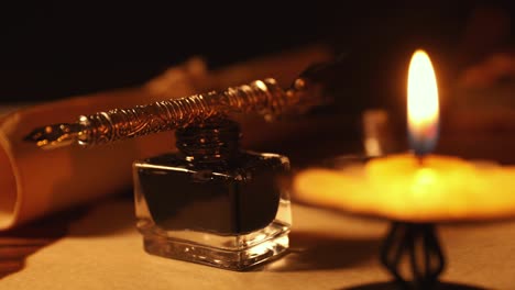 pluma de pluma vintage y tintero en papel de pergamino viejo a la luz de las velas