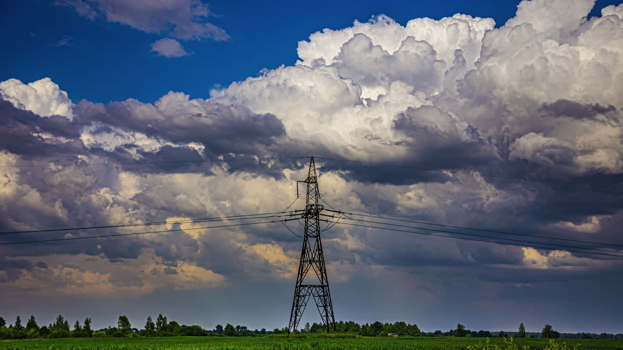 Clouds passing behind a transmission tower in the countryside - time lapse