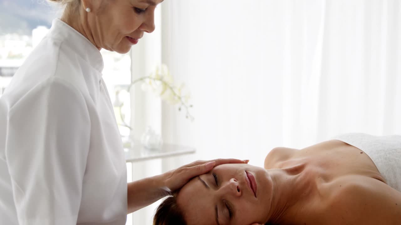 Terapeuta massageando a cabeça de sua paciente