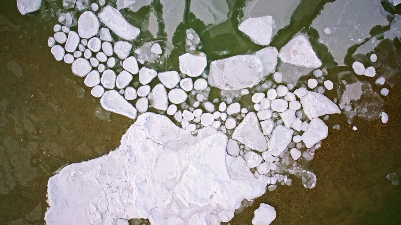 Riprese aeree con drone che mostrano dall'alto intricate formazioni di ghiaccio che coprono la superficie dei Grandi Laghi.