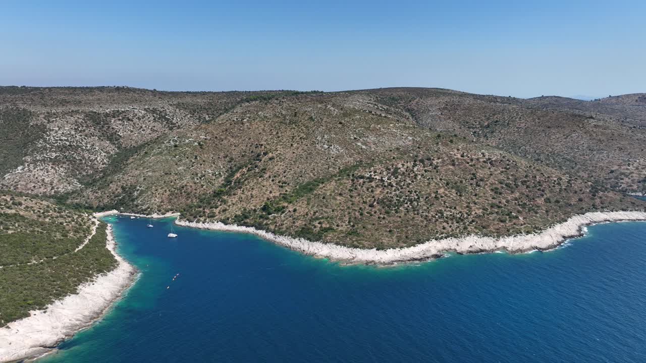 Aerial view of serene coastal landscape with clear blue sea and hills