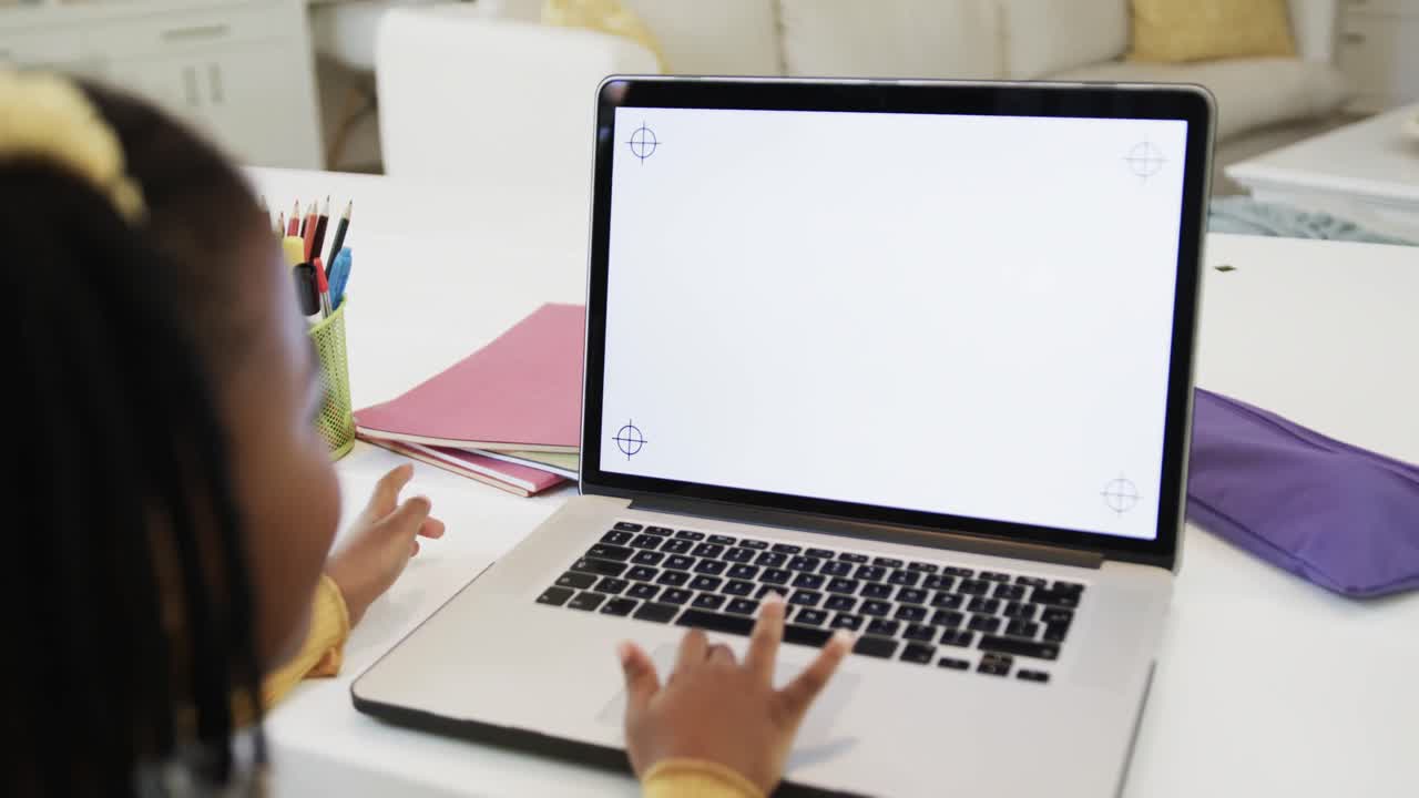 Happy african american girl waving in online class, using laptop with copy space, slow motion