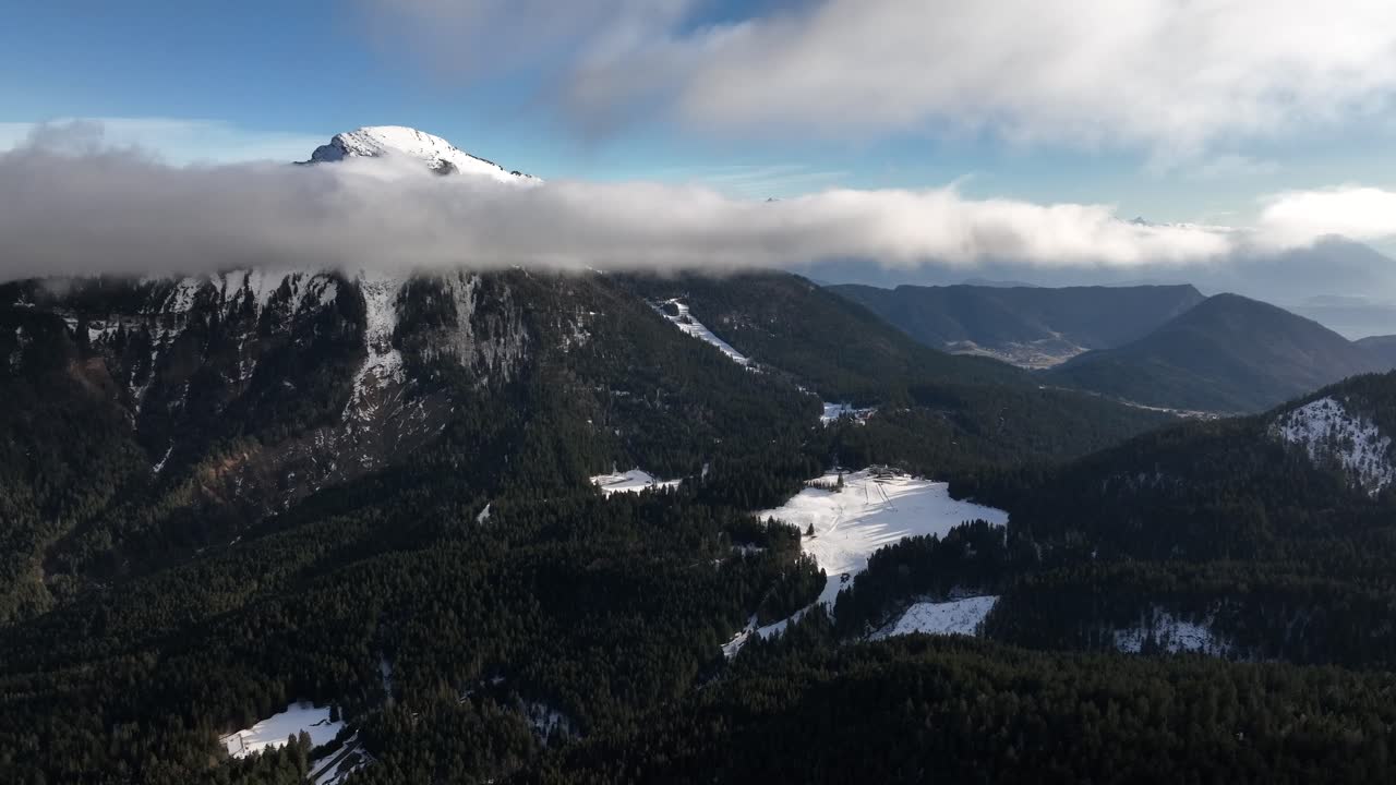 montaña nebulosa con nieve y una gran nube frente a la cumbre, chamrousse