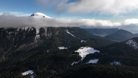 Misty-mountain-with-snow-and-large-cloud-in-front-of-the-summit,-Chamrousse