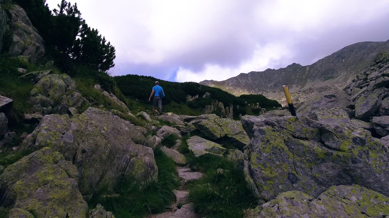 excursionistas caminando por la ladera de una montaña en la ladera rocosa de rumania