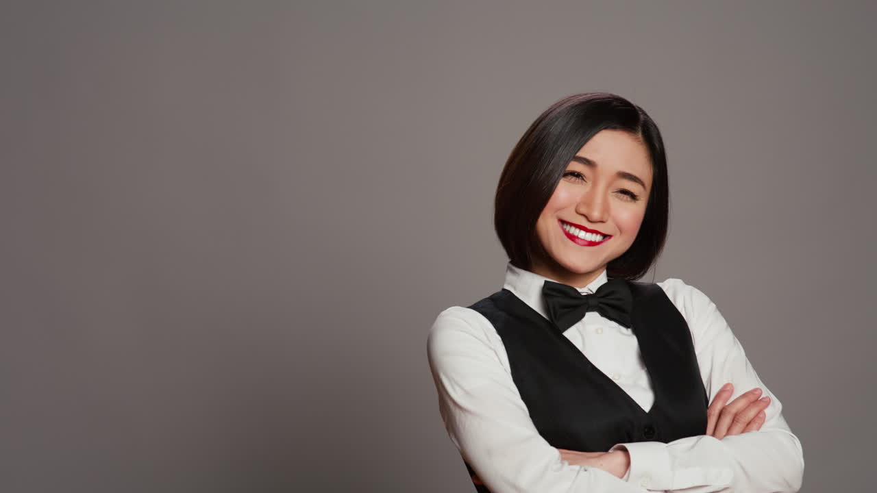La concierge asiatica dell'hotel indossa un'elegante uniforme con un fiocco