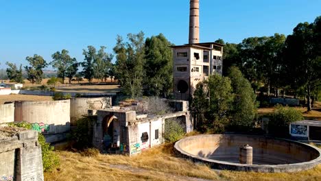 aerial elevation view of a ruined cement factory with the silos and other processing parts of the complex - drone shot