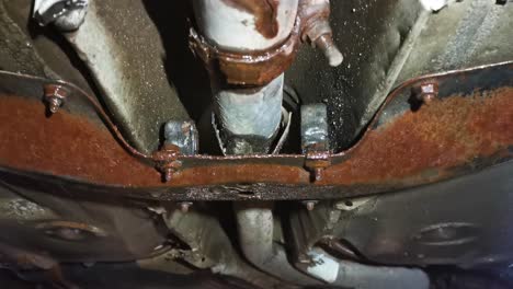 view of rusted exhaust pipe on lifted car