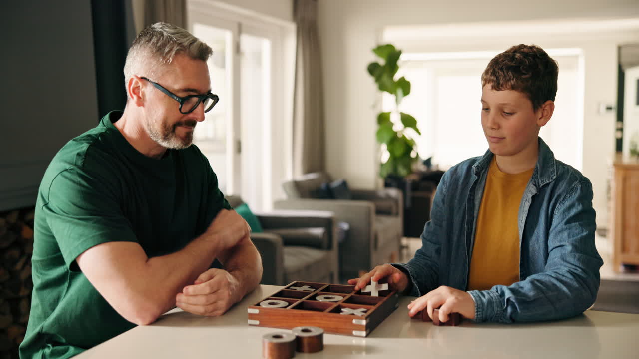Father and Son Playing Tic-Tac-Toe at Home