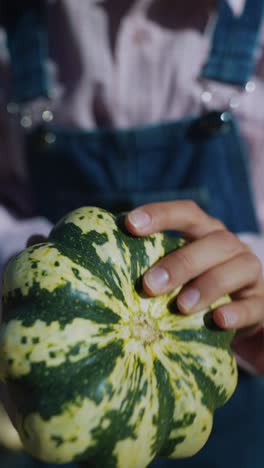 person holding a small pumpkin