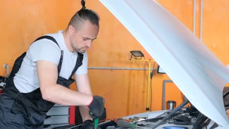 auto mechanic working on a car engine in a garage