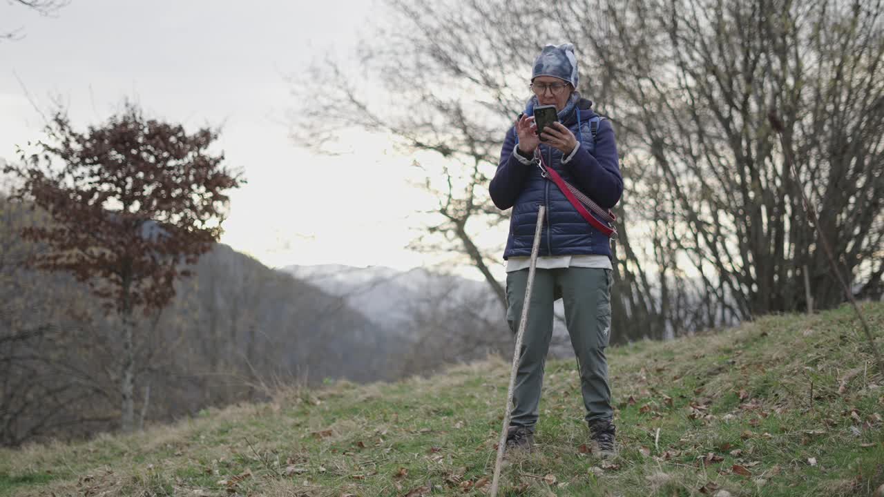 Woman Hiking in Mountains Using Phone
