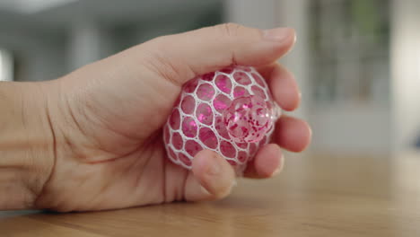 person holding a pink glitter stress ball