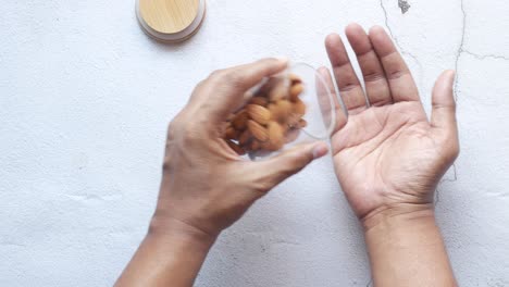 pouring almonds from jar into hand