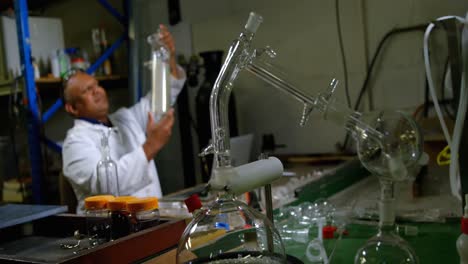 front view of mature male worker checking glass product in glass factory 4k