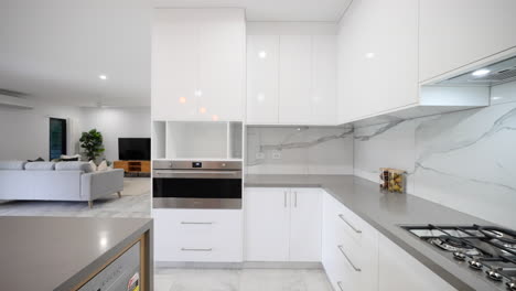 white marble tiled wonder kitchen with grey stone bench tops white and wooden cupboard doors