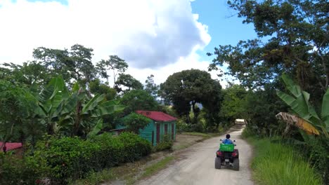 a woman and a boy driving in a rural street of the caribbean in a community called san jose de ocoa, at the dominican republic , the road is bumpy and the day is sunny